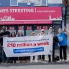 Campaigners at Wes Streeting's office with banner that reads "We lose £10 million a week in private profits from the NHS"